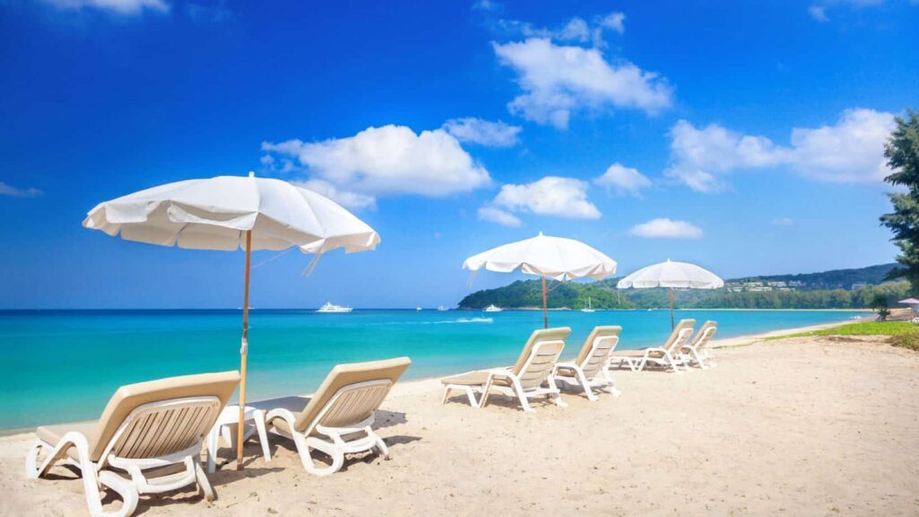 a photo of a beach with beach beds to signify getting into vacation mode during staycation.