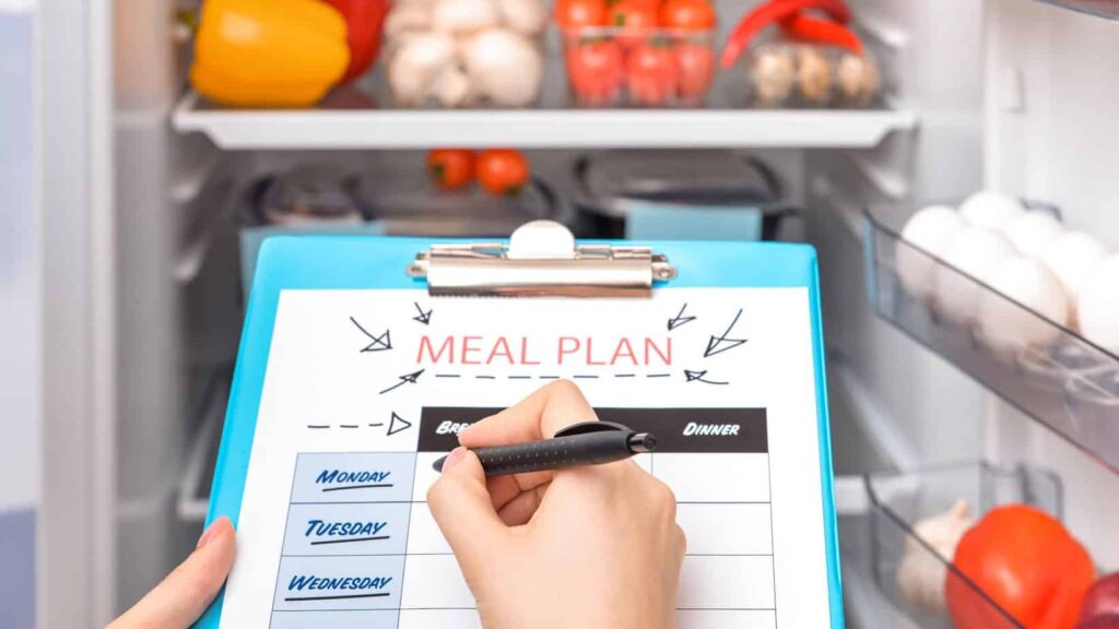 a photo of a meal plan and a refrigerator that signifies to make the meal ahead - another tip on how to plan a family staycation with toddlers.