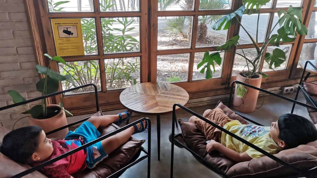 photo of two toddler boys sitting on chairs in a local cafe, enjoying their staycation.