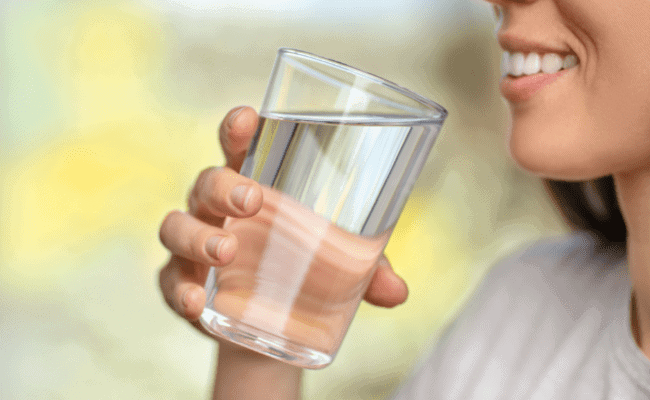 a woman holding a glass of water