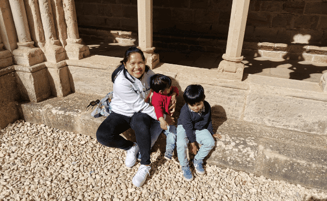 a picture of a mother in black jeans and white hoodie with her two toddlers - mother is practicing modest dressing and no more worries about showing unnecessary body parts when bending and chasing her kids