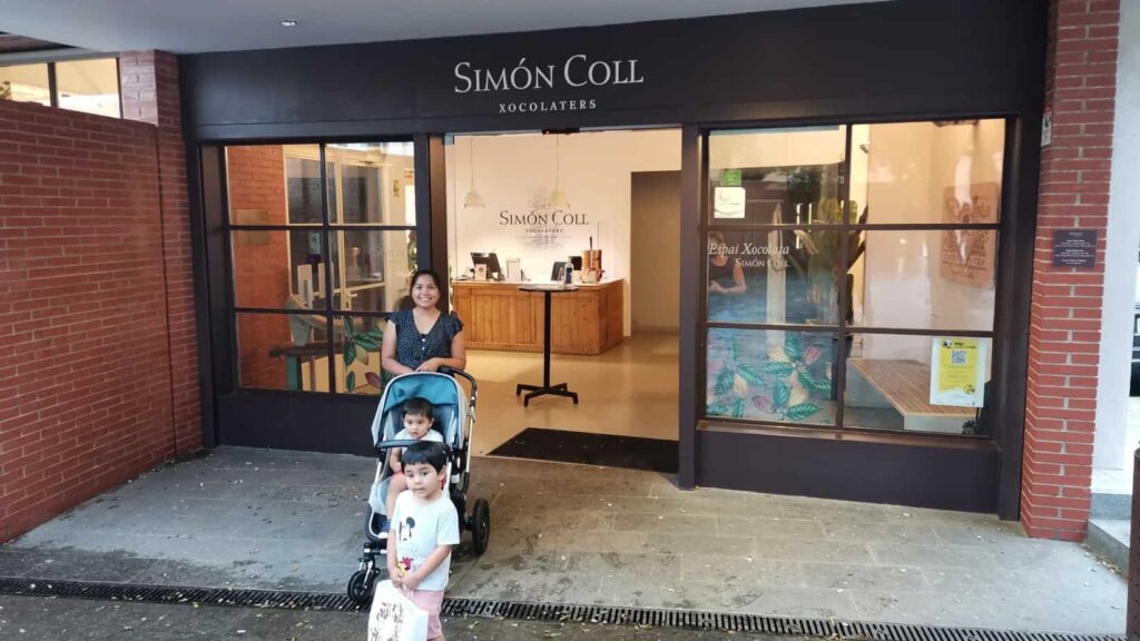 a photo of a mother with her two toddlers in front of Simon Coll chocolate factory.