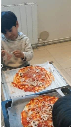 kids helping in making homemade pizza - one of the most affordable and fun family staycation ideas
