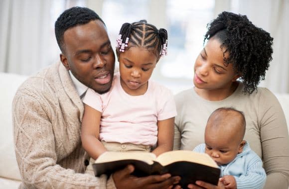 photo of a family reading a Bible as one of the Catholic staycation ideas for families